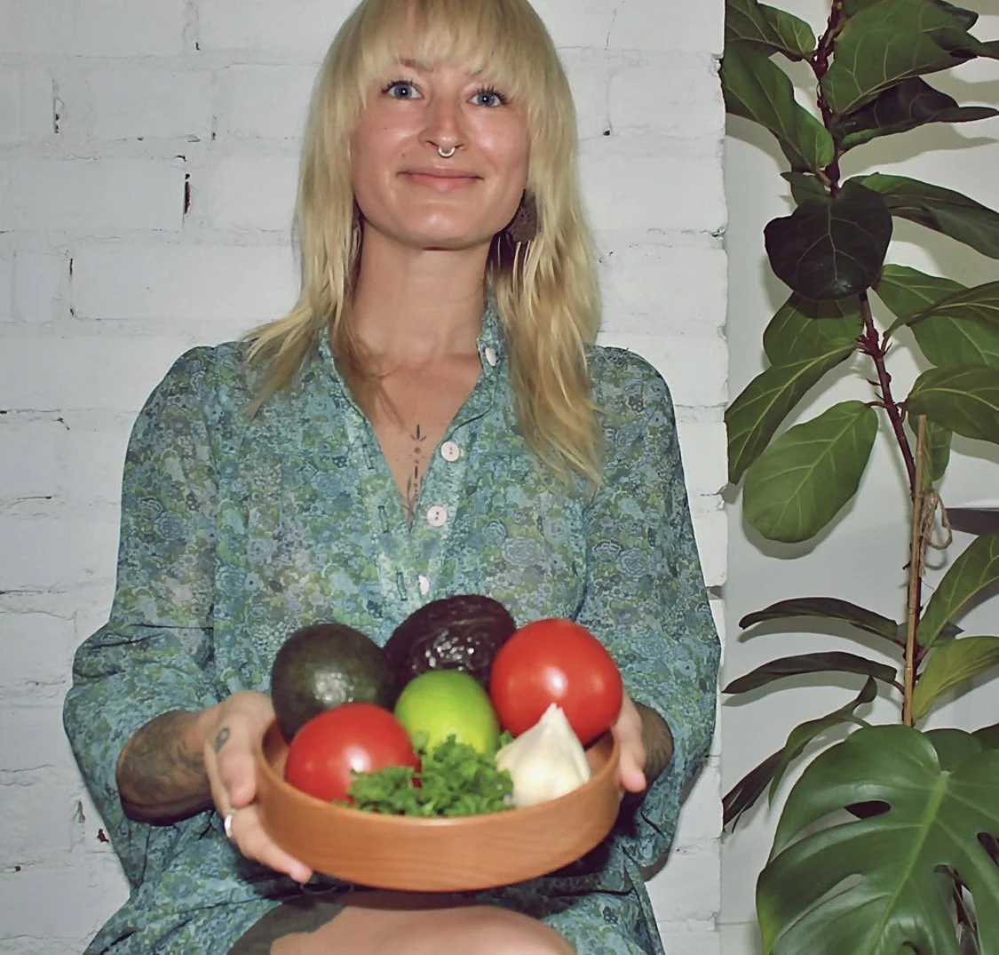 Lindsay, Certified Holistic Nutritionist, holding a bowl of fresh produce